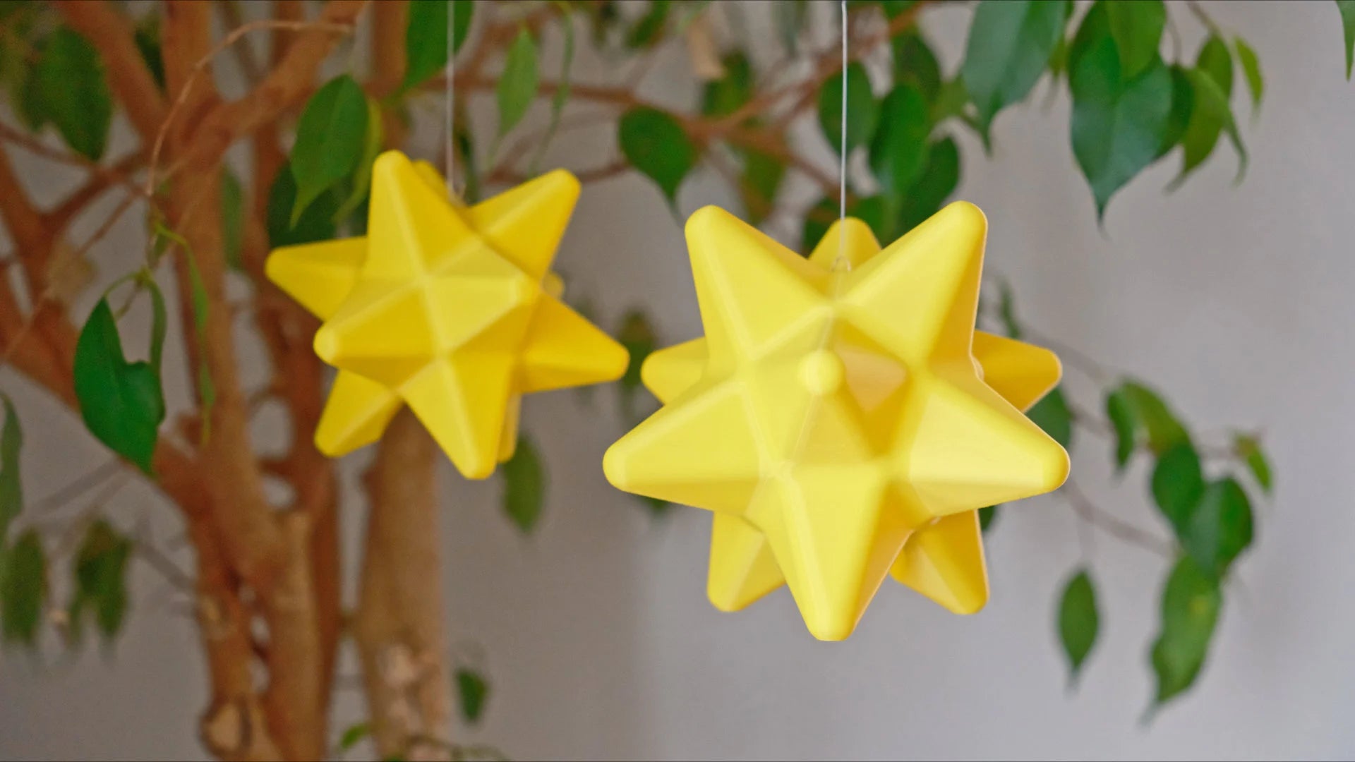 dodecahedron star fragments inspired by animal crossing hanging from thin strings attached to a tree