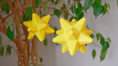 dodecahedron star fragments inspired by animal crossing hanging from thin strings attached to a tree